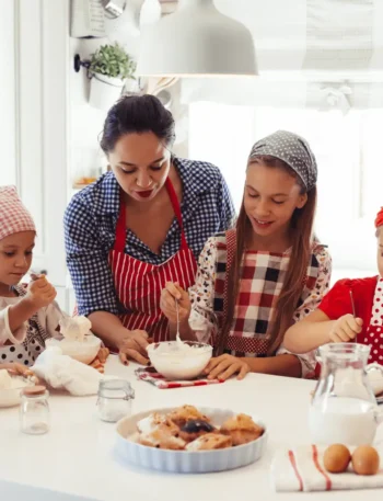 mulher ensinando crianças a cozinhar